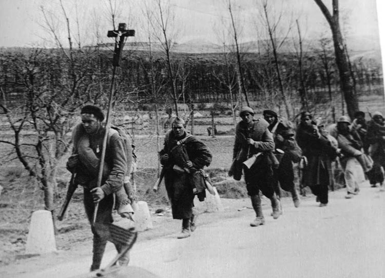 Imagen en blanco y negro de un grupo de personas caminando en la nieve
Descripción generada automáticamente